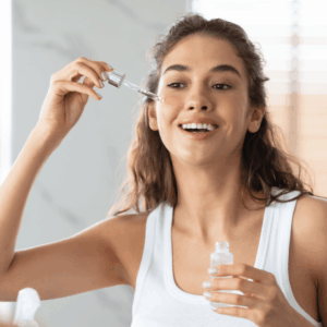 Frau trägt mit einer Pipette ein Anti-Aging-Serum auf die Haut auf – Gesichtspflege für strahlenden Teint