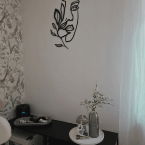 Dekorative Ecke im Kosmetikstudio Bio Beauty Attack in Gütersloh mit Wandkunst, Blütenzweigen und sanftem Licht.