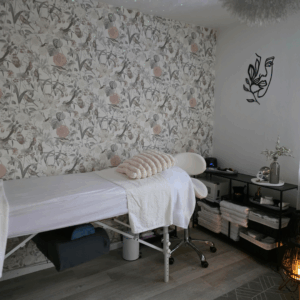 Behandlungsraum im Kosmetikstudio Bio Beauty Attack in Gütersloh mit Liege, floraler Tapete und harmonischer Atmosphäre.