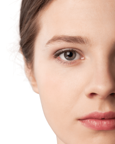 Eine junge Frau mit glatter, gepflegter Haut schaut ruhig in die Kamera. Nur eine Gesichtshälfte ist sichtbar. Das Bild vermittelt Ruhe