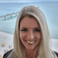 Porträt einer lächelnden Frau mit blonden Haaren am Meer – Inhaberin von Bio Beauty Attack in Gütersloh, spezialisiert auf Kobido-Gesichtsmassage, Naturkosmetik und ganzheitliche Anti-Aging-Behandlungen.