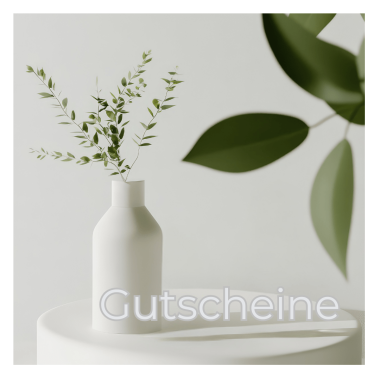 Eine weiße Vase mit grünen Zweigen steht auf einem weißen Tisch. Im Vordergrund ist der Schriftzug ‚Gutscheine‘ zu sehen. Im Hintergrund verschwommene grüne Blätter.